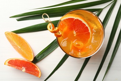 Delicious orange soda water on white wooden table, flat lay