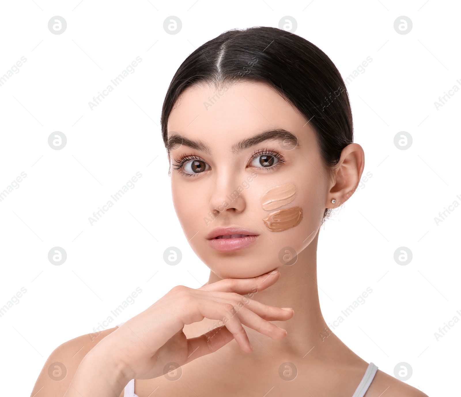 Photo of Teenage girl with swatches of foundation on face against white background