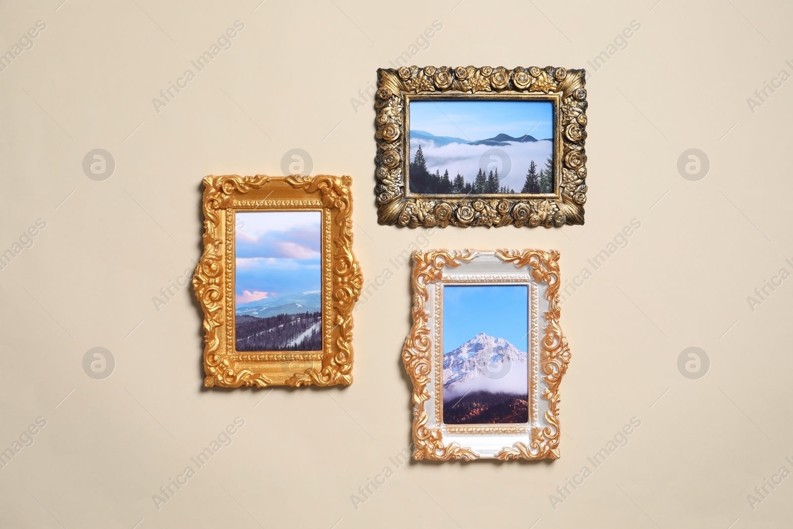 Photo of Vintage frames with photos of beautiful landscapes hanging on beige wall