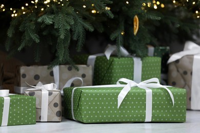 Photo of Beautiful colorful gifts under Christmas tree indoors