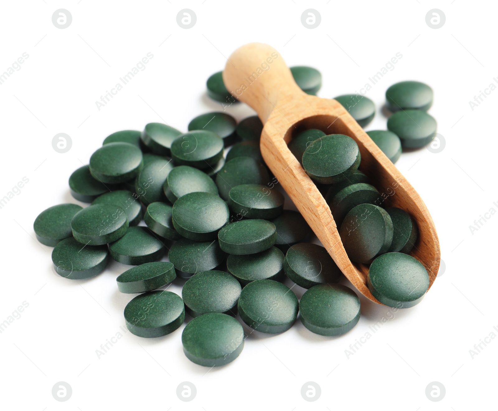 Photo of Scoop and spirulina tablets on white background