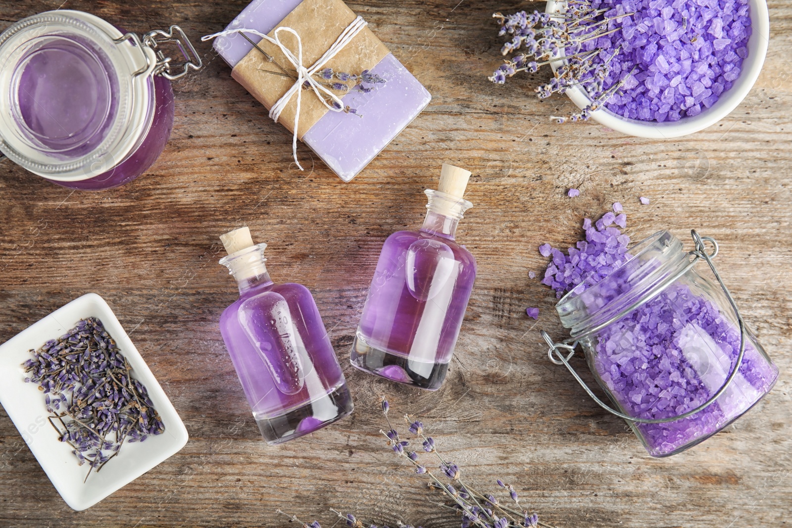 Photo of Flat lay composition with natural herbal oil and lavender flowers on wooden background