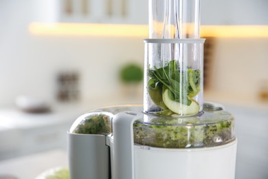Photo of Modern juicer with fresh spinach and fruits in kitchen, closeup