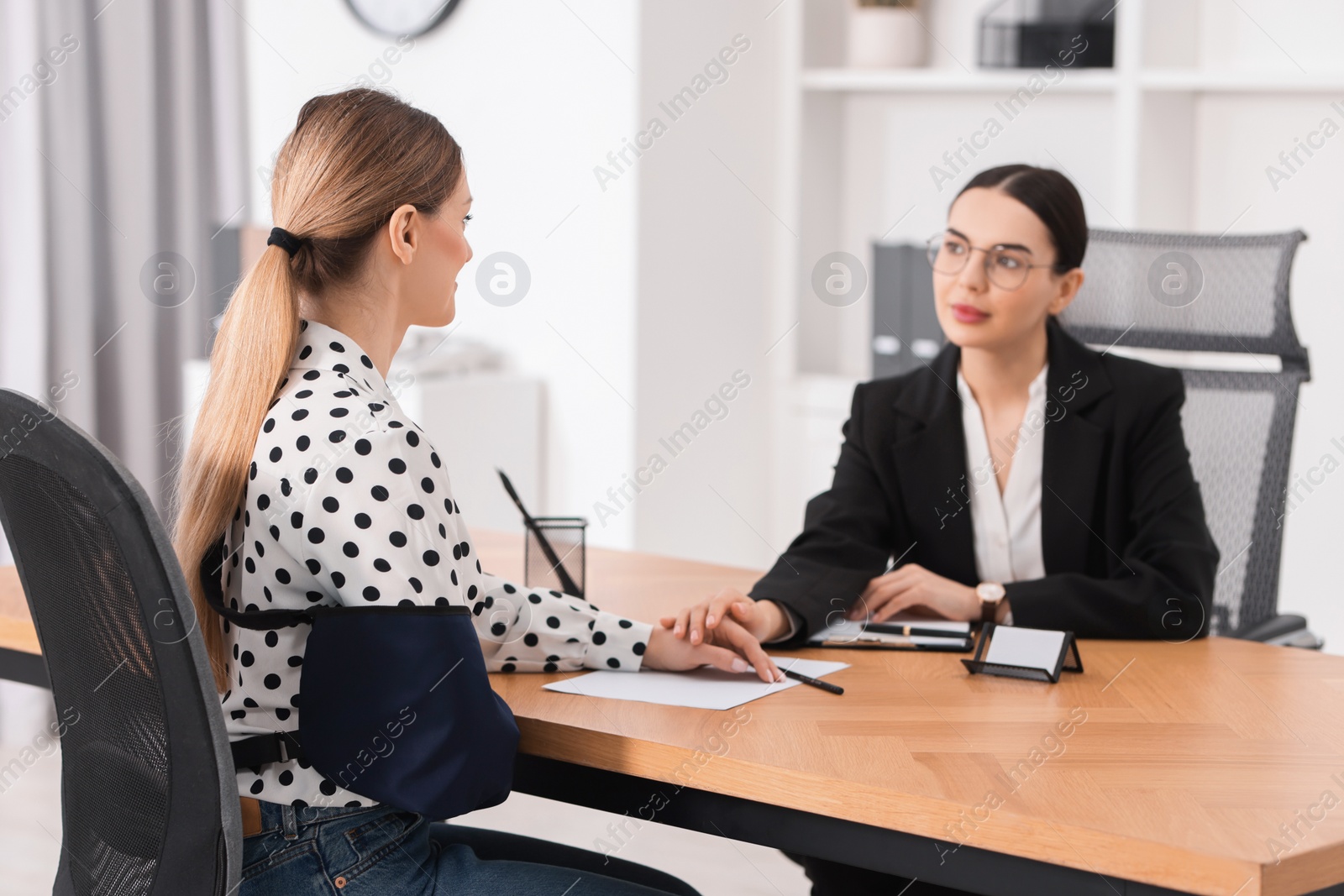 Photo of Injured woman having meeting with lawyer in office