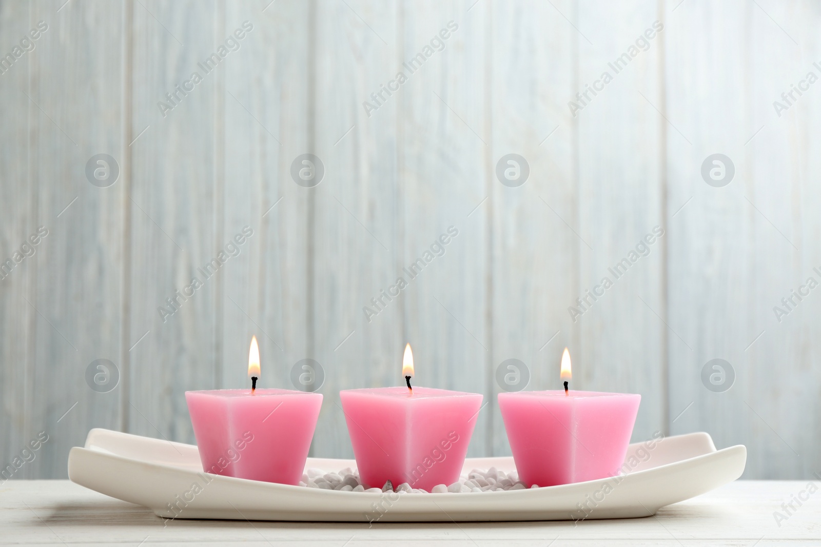 Photo of Composition with three burning candles on white table. Space for text