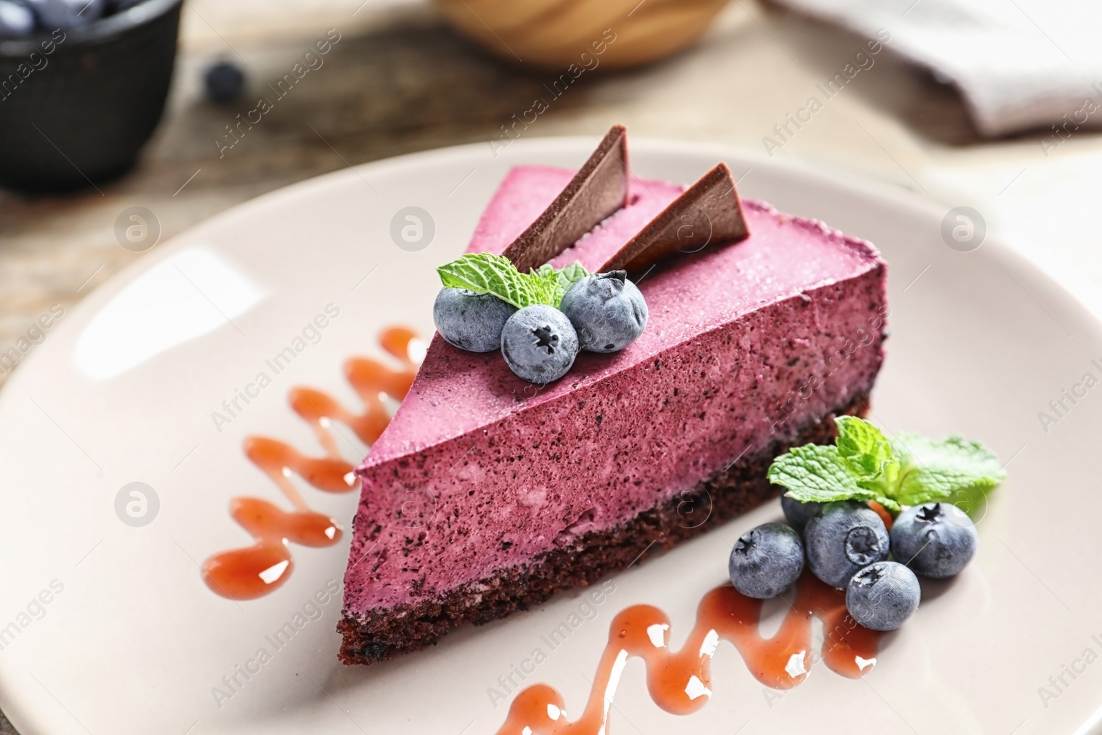 Photo of Plate with piece of tasty blueberry cake on table