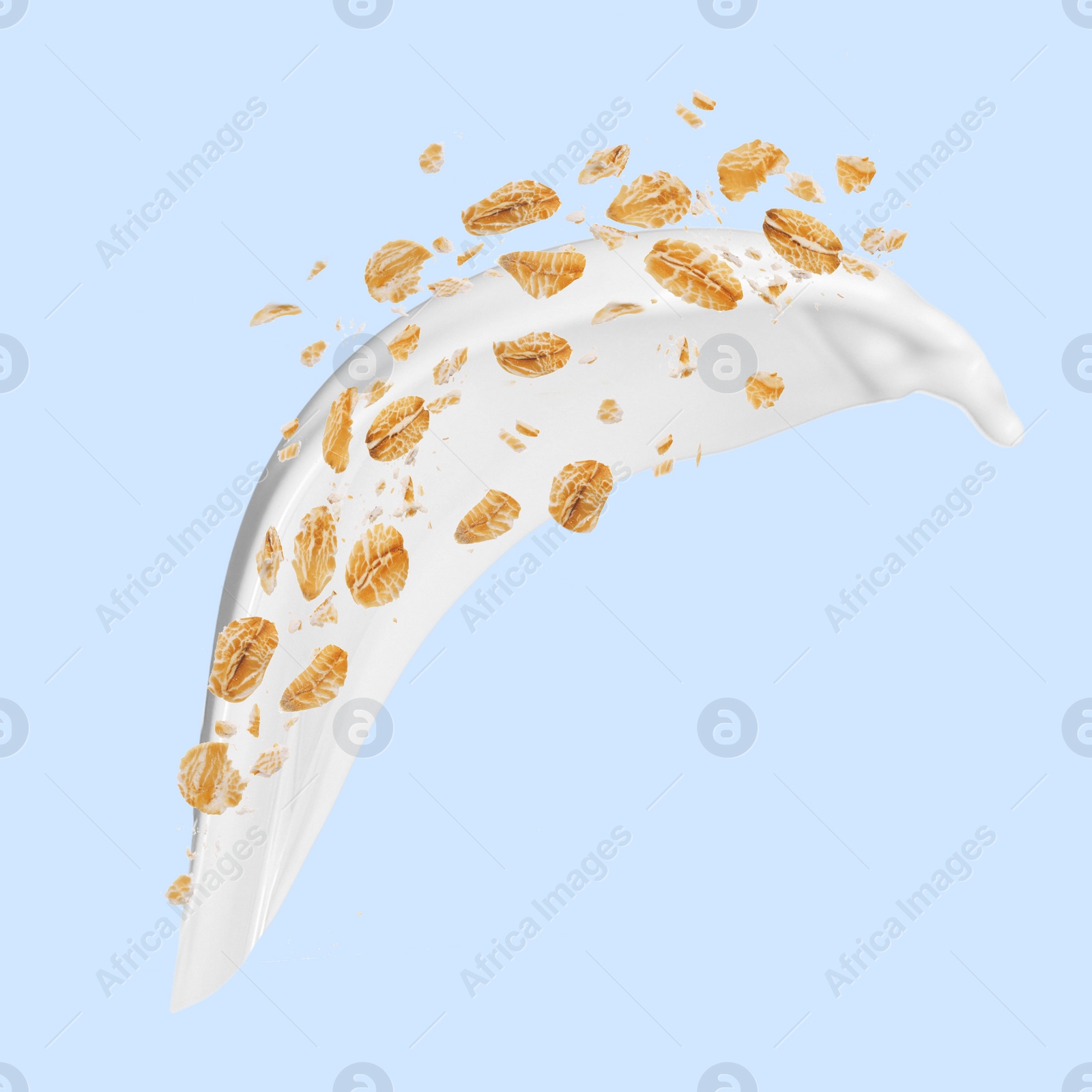 Image of Rolled oats and milk splash on light blue background