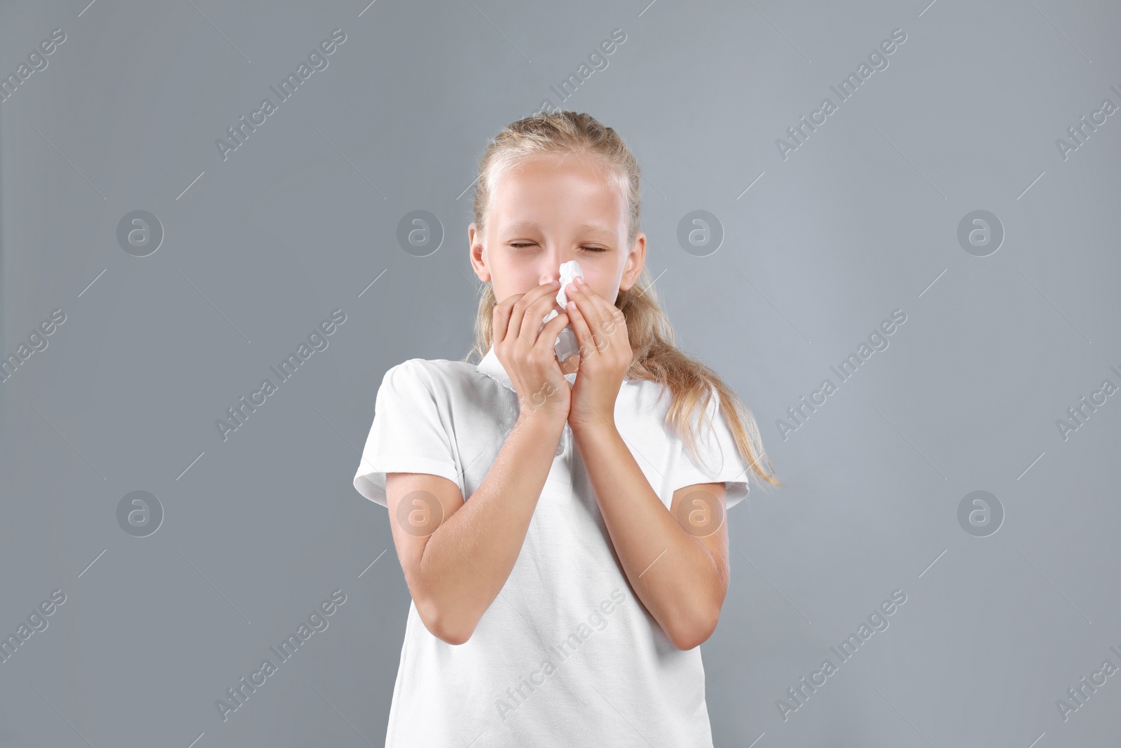 Photo of Little girl suffering from allergy on grey background