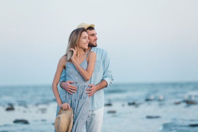 Photo of Young couple spending time together on beach