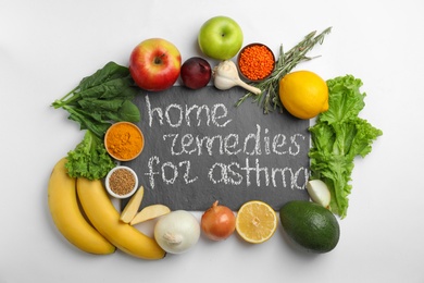 Photo of Natural products and slate board with text HOME REMEDIES FOR ASTHMA on white background, top view