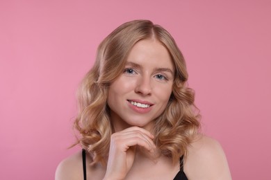 Photo of Portrait of beautiful woman with blonde hair on pink background