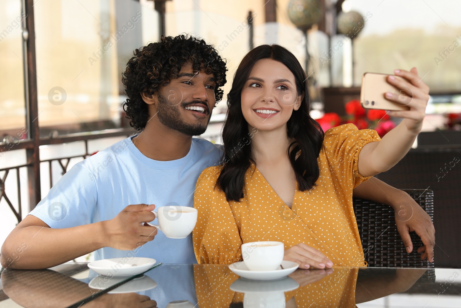 Photo of International dating. Happy couple taking selfie in restaurant