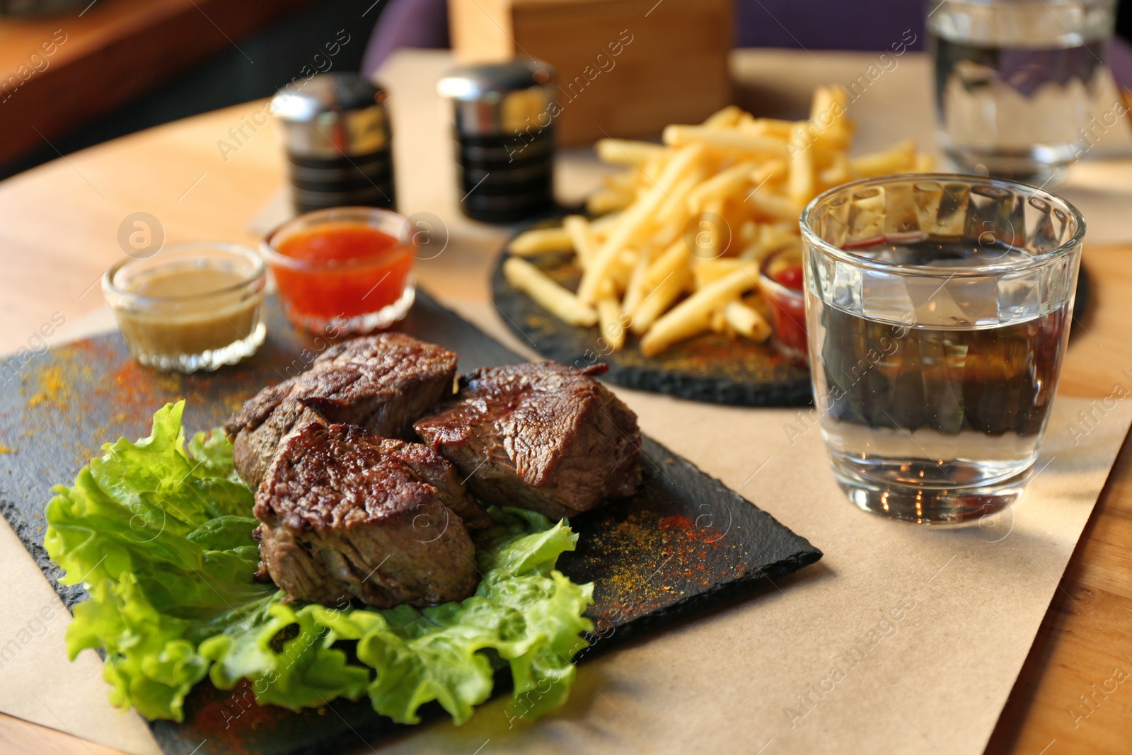 Photo of Tasty pieces of shish kebab served on slate plate in cafe