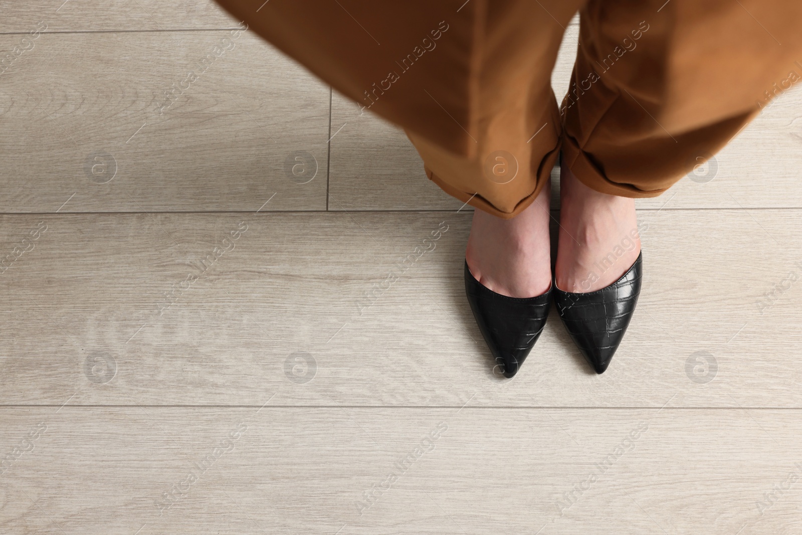 Photo of Businesswoman in leather shoes on floor, above view. Space for text