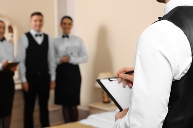 Group of people attending professional butler courses in hotel, closeup and space for text