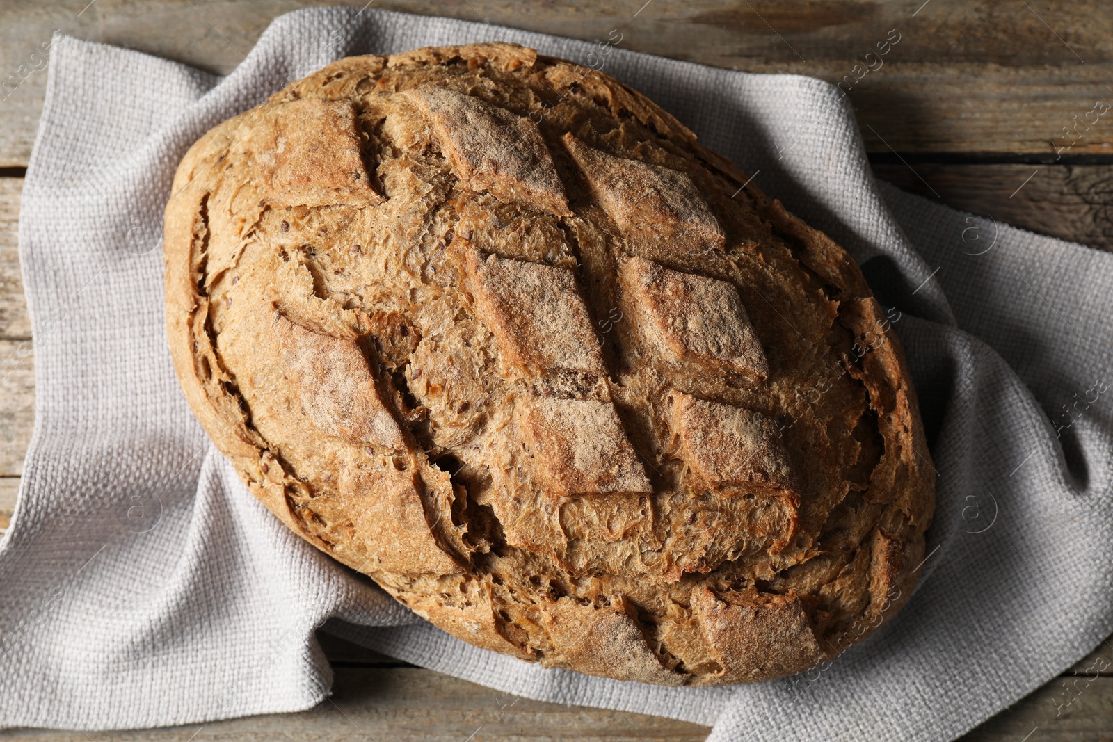 Photo of Freshly baked sourdough bread on wooden table, top view