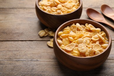 Photo of Tasty cornflakes with milk served on wooden table. Space for text