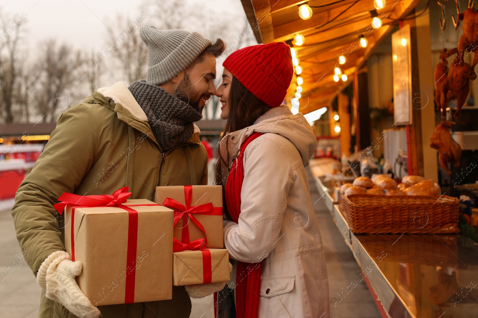 Photo of Lovely couple with Christmas presents at winter fair