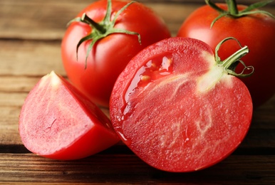 Fresh ripe tomatoes on wooden table, closeup