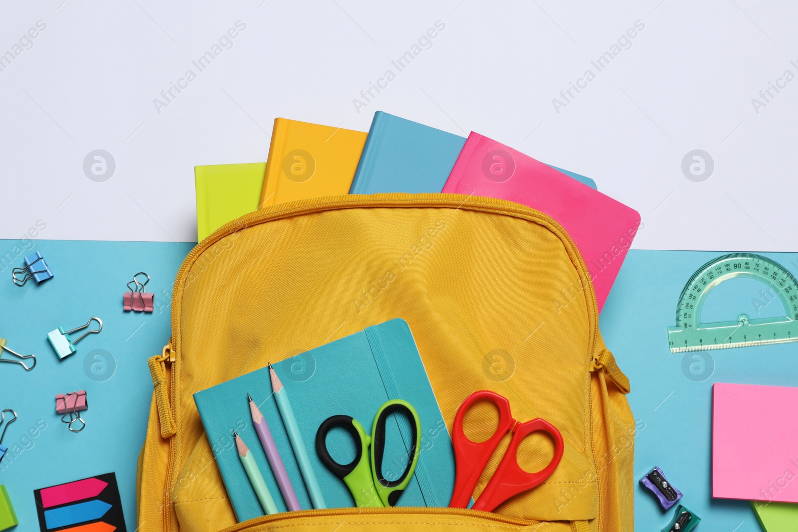 Photo of Backpack with different school stationery on color background, flat lay
