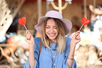 Beautiful woman with candies having fun at amusement park