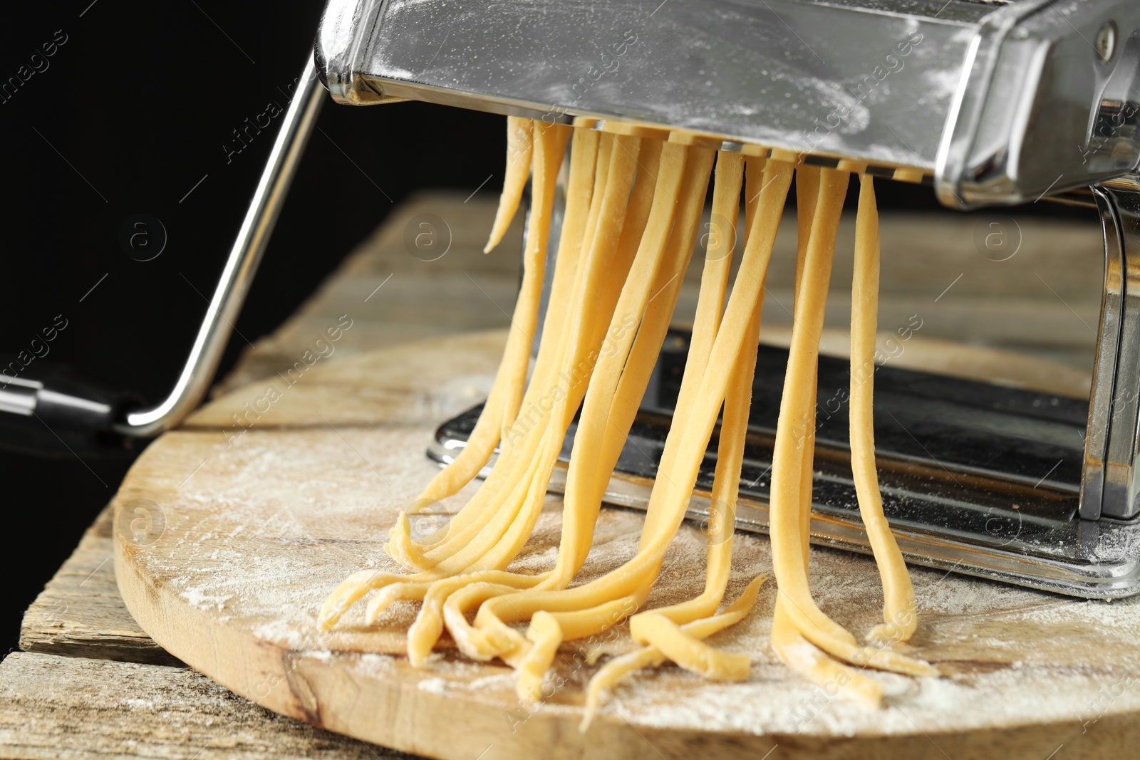 Photo of Pasta maker with raw dough on wooden table