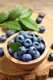 Bowl of fresh tasty blueberries on table, closeup. Space for text