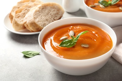 Photo of Bowl of tasty sweet potato soup on table