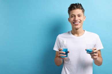 Photo of Young man with mouthwash on light blue background, space for text