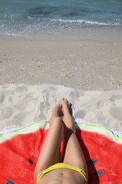 Woman with beach towel on sand near sea, closeup