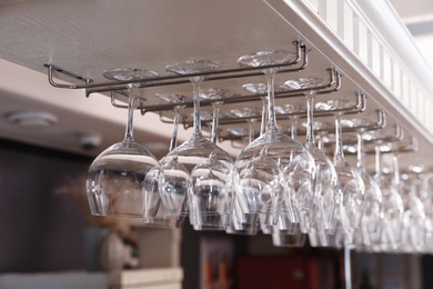 Set of empty clean glasses on bar racks