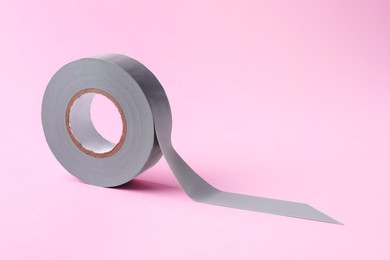 Photo of Grey insulating tape on pink background. Space for text