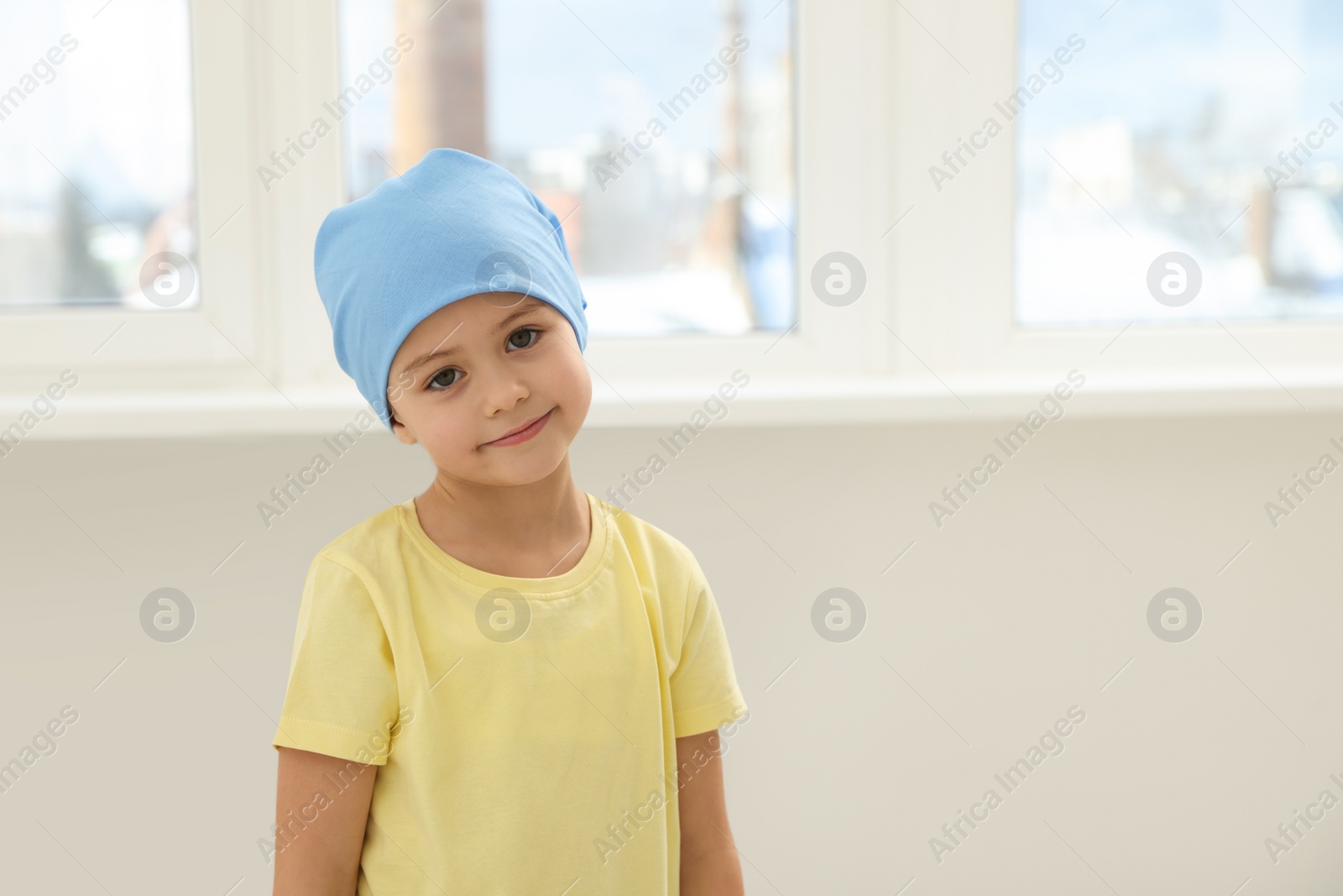 Photo of Childhood cancer. Girl with handkerchief in hospital, space for text