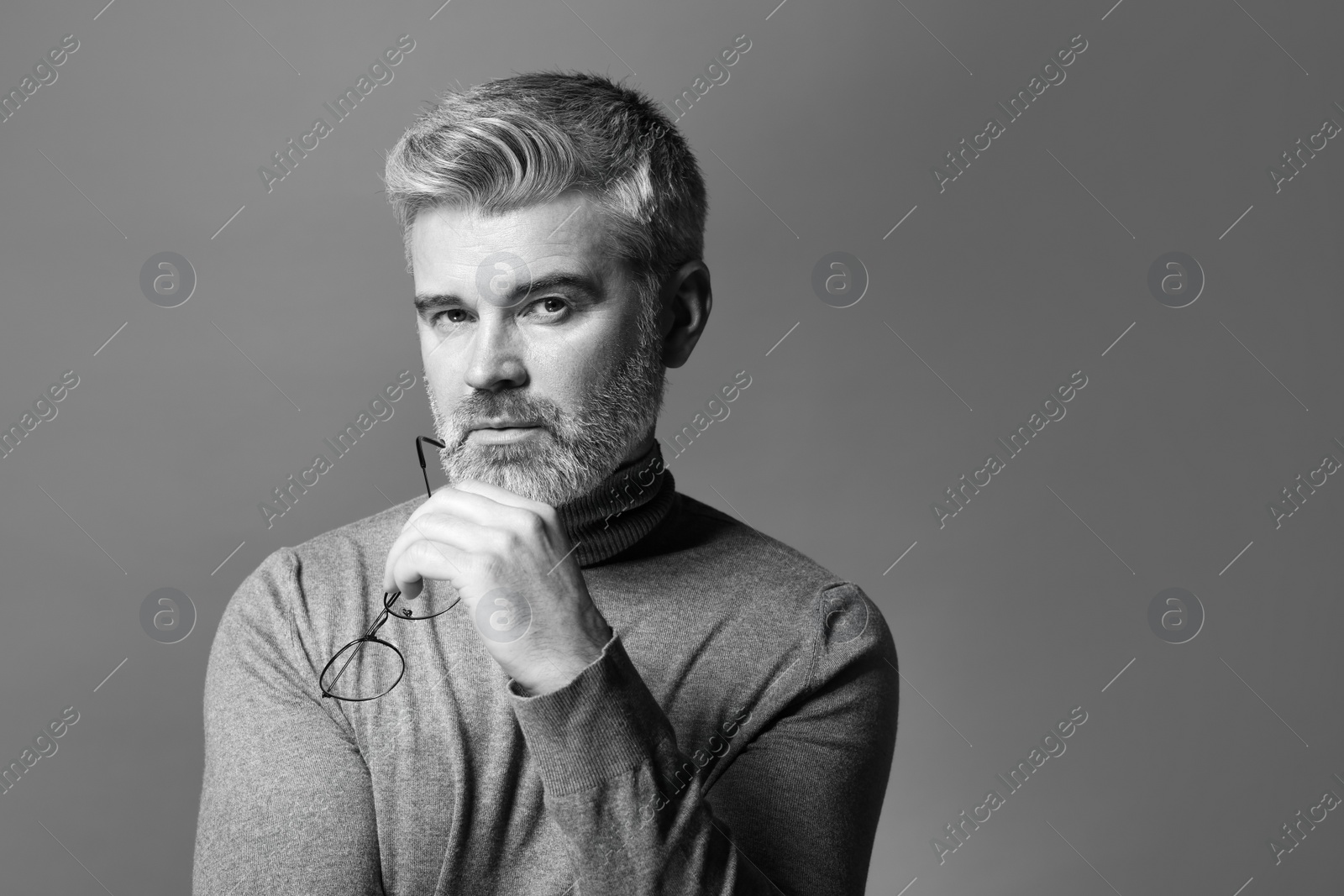 Photo of Portrait of handsome man on grey background, space for text. Black and white effect