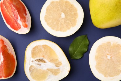 Photo of Different sorts of tasty pomelo fruits on dark blue background, flat lay