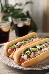 Photo of Delicious hot dogs with onion, chili pepper and sauce on table, closeup. Space for text