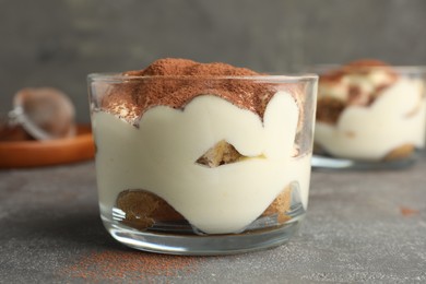 Delicious tiramisu in glass on grey table