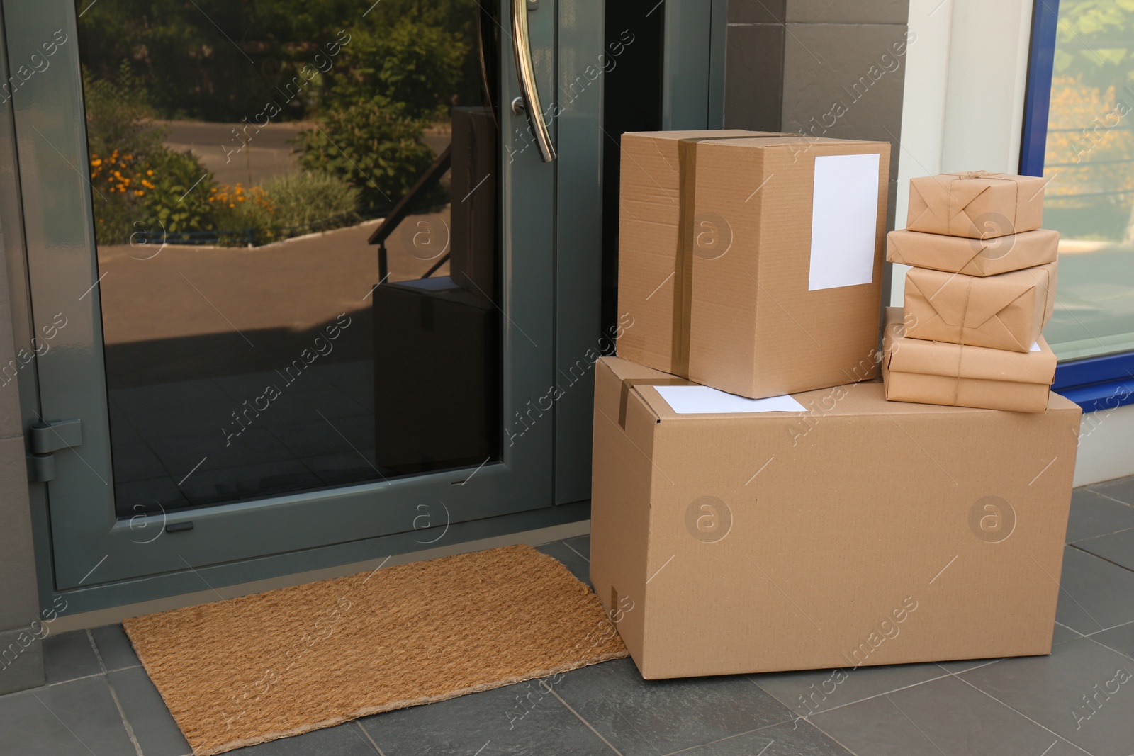 Photo of Cardboard boxes near door. Parcel delivery service