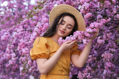 Photo of Beautiful woman near blossoming sakura tree on spring day