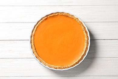 Photo of Fresh delicious homemade pumpkin pie on wooden background, top view