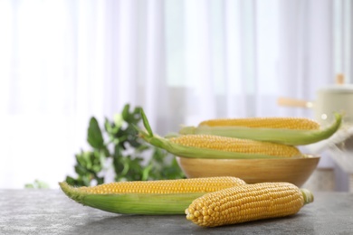 Photo of Tasty sweet corn cobs on table