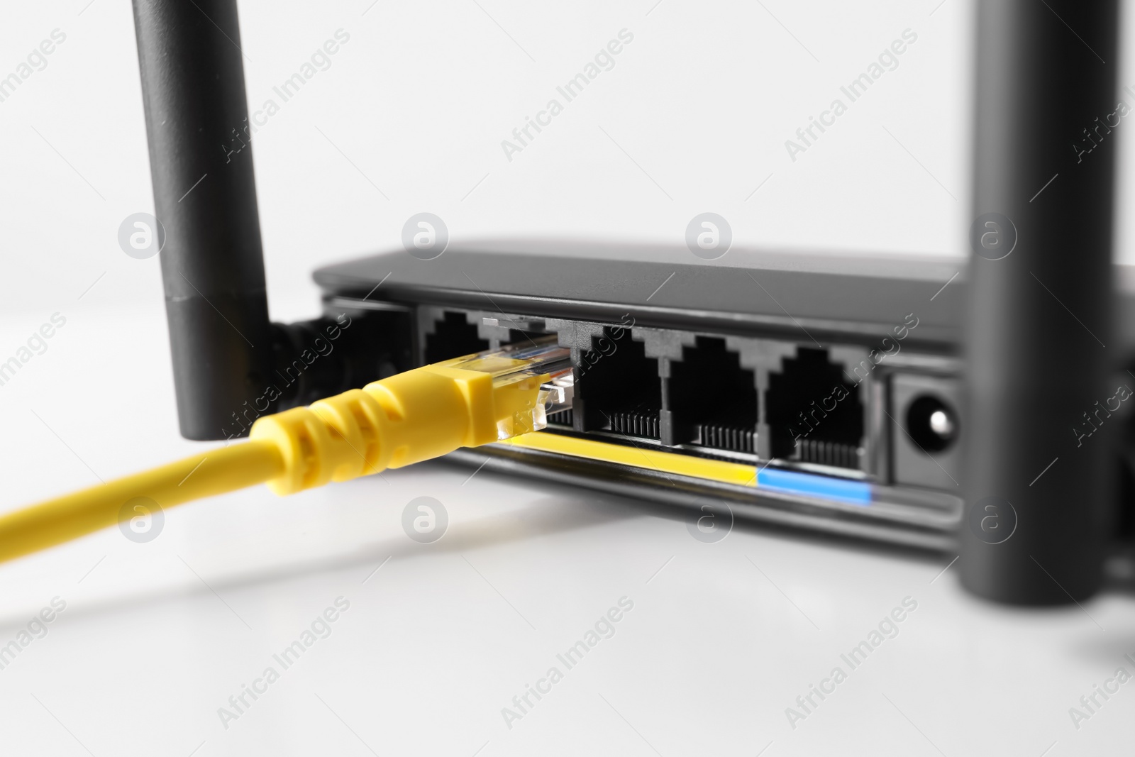 Photo of Connected cable to router on white table, closeup. Wireless internet communication