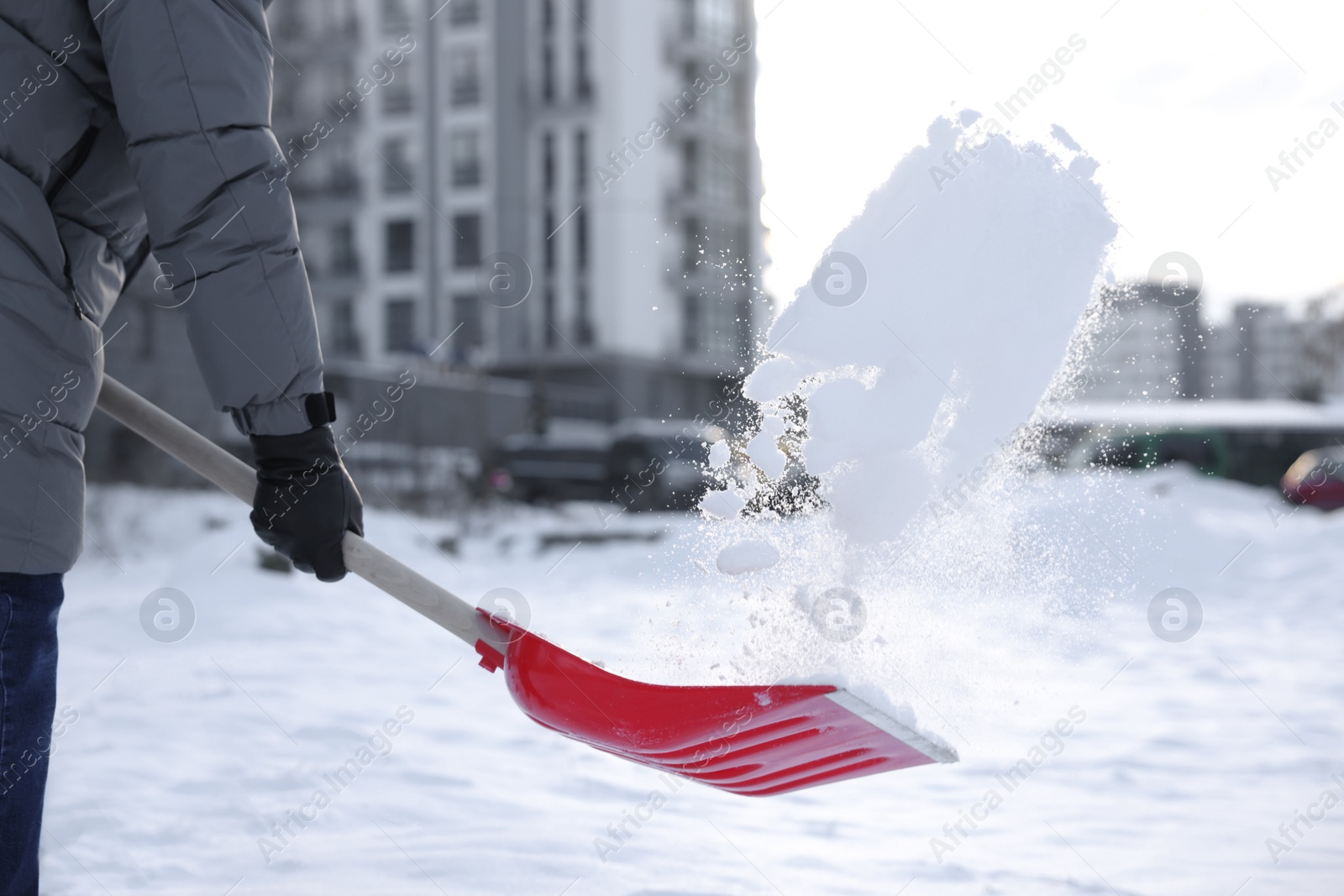 Photo of Man removing snow with shovel outdoors, closeup