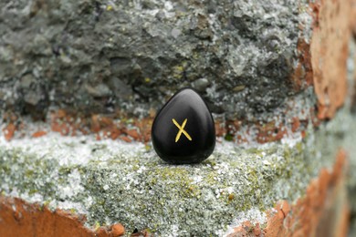 Photo of Black rune Gebo on stone outdoors, closeup