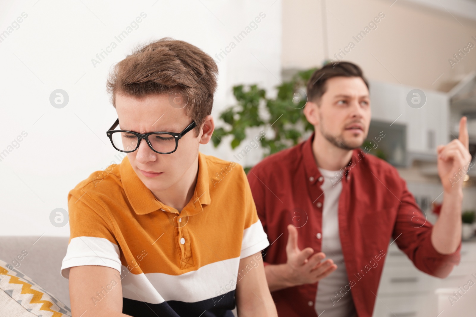 Photo of Father scolding his teenager son at home