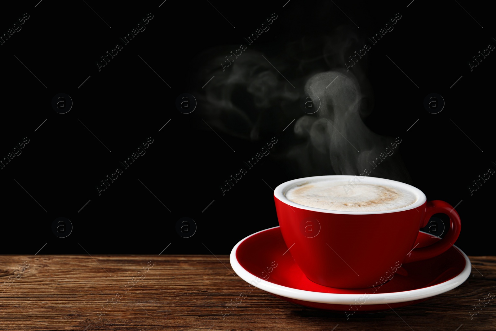 Image of Red cup with hot steaming coffee on wooden table against black background, space for text