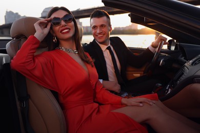 Beautiful couple in luxury convertible car outdoors