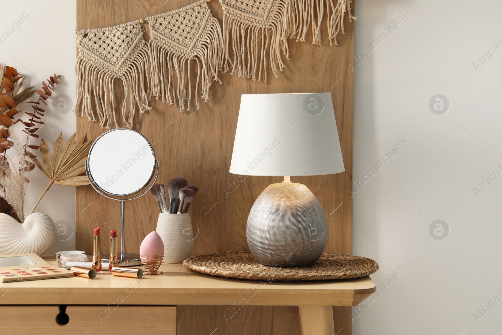 Photo of Dressing table with mirror, makeup products and decor in room
