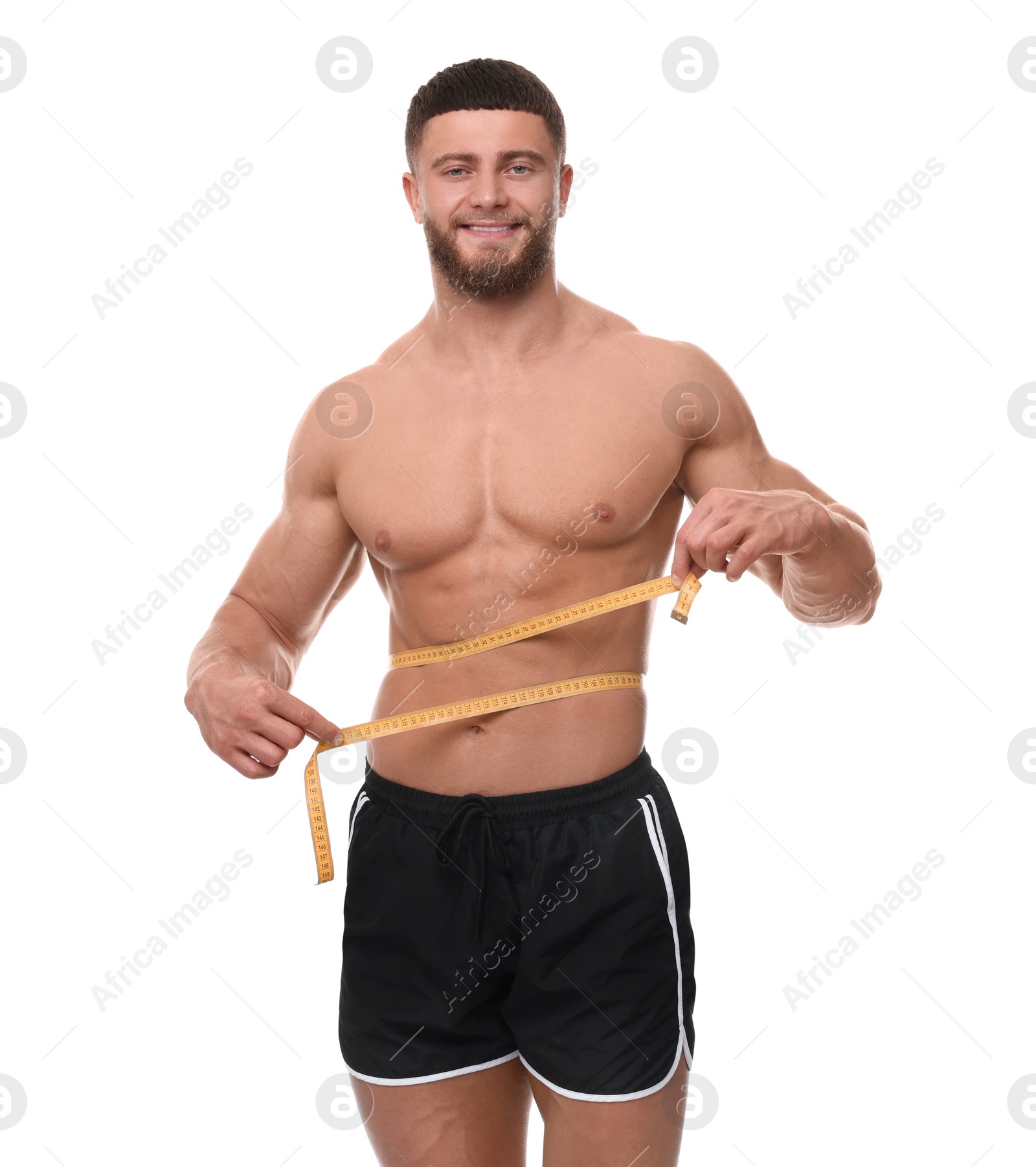 Photo of Happy athletic man measuring waist with tape on white background. Weight loss concept