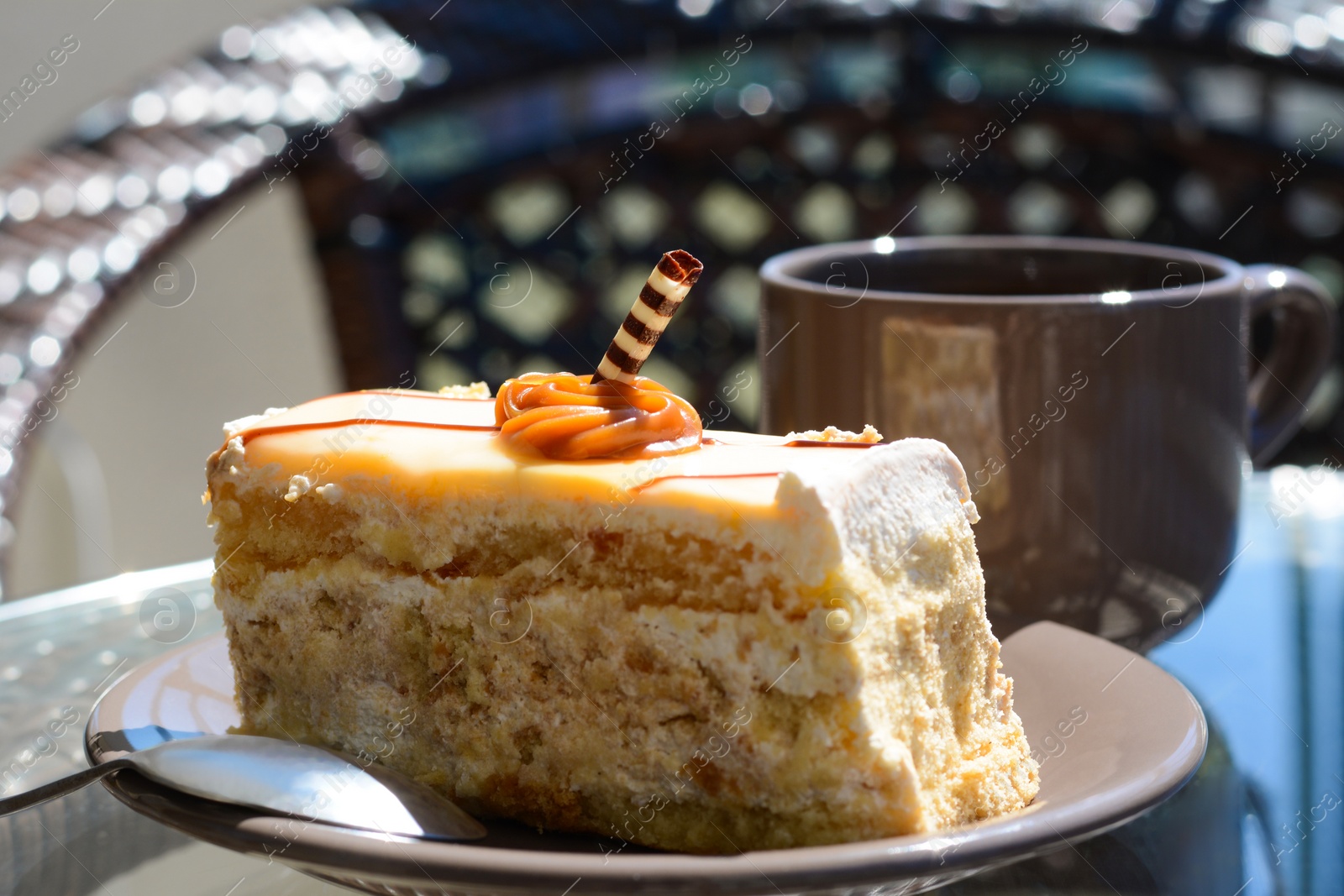 Photo of Tasty dessert and cup of fresh aromatic coffee on glass table outdoors, closeup